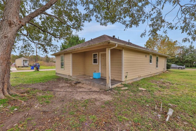 424 Baker Cir, Ames, TX 77575 - view of property exterior with a lawn and a patio