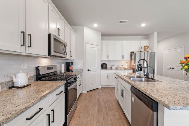 5732 Palm Flower Dr, Montgomery, TX 77316 - kitchen featuring stainless steel appliances, a sink, white cabinets, a center island with sink, and recessed lighting