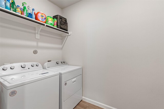 5732 Palm Flower Dr, Montgomery, TX 77316 - washroom with washing machine and clothes dryer, light wood finished floors, and baseboards