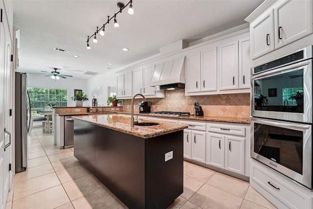 21885 Lost Mdw, New Caney, TX 77357 - kitchen featuring appliances with stainless steel finishes, a sink, custom exhaust hood, light tile patterned floors, and recessed lighting