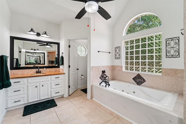 21885 Lost Mdw, New Caney, TX 77357 - full bathroom with a ceiling fan, a jetted tub, vanity, vaulted ceiling, and tile patterned flooring