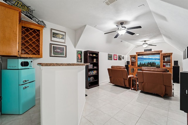 21885 Lost Mdw, New Caney, TX 77357 - home theater with ceiling fan, vaulted ceiling, built in features, light tile patterned flooring, and a textured ceiling
