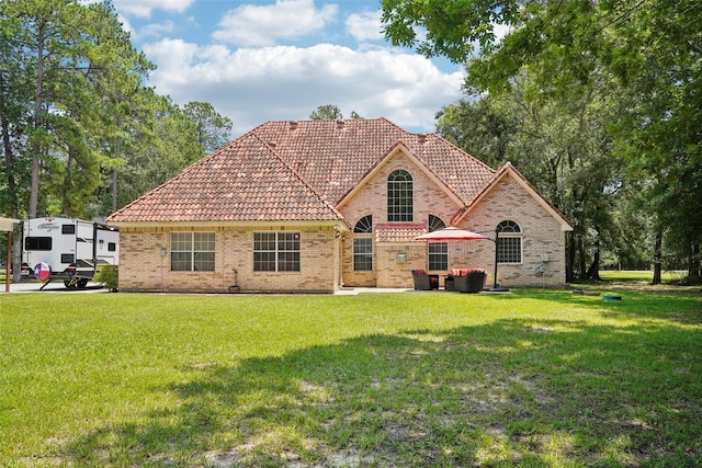 21885 Lost Mdw, New Caney, TX 77357 - view of front of home with a tile roof, brick siding, and a front yard