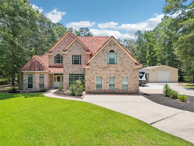 21885 Lost Mdw, New Caney, TX 77357 - view of front of house featuring a tile roof, an outdoor structure, a detached garage, concrete driveway, and a front lawn