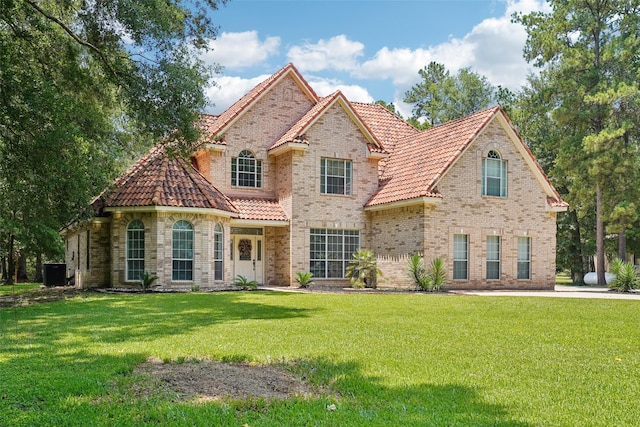 21885 Lost Mdw, New Caney, TX 77357 - view of front of property featuring a tiled roof, a front lawn, cooling unit, and brick siding