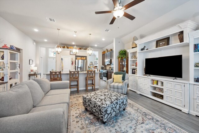 1010 Old Vine Rd, Brenham, TX 77833 - living area with wood finished floors, a ceiling fan, recessed lighting, and a chandelier