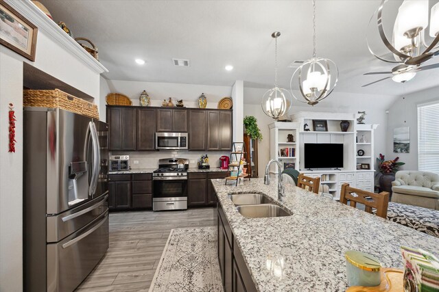 1010 Old Vine Rd, Brenham, TX 77833 - kitchen with appliances with stainless steel finishes, a sink, open floor plan, dark brown cabinets, and ceiling fan