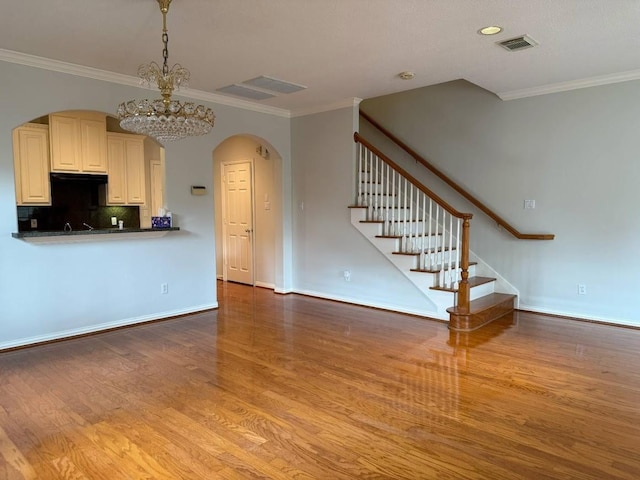 7222 Harmony Cv, Houston, TX 77036 - unfurnished living room with arched walkways, wood finished floors, stairway, ornamental molding, and a chandelier