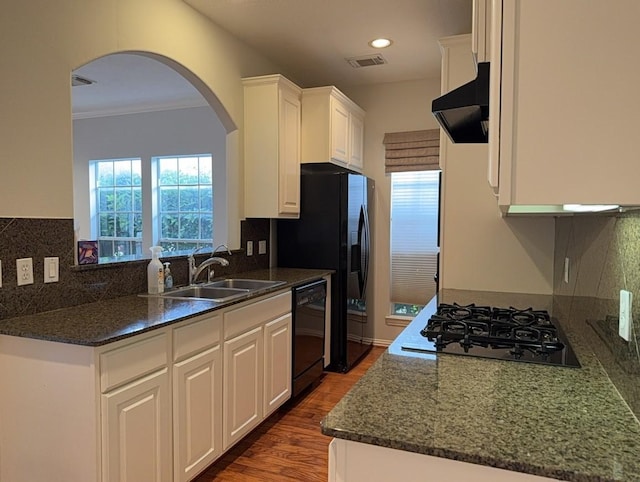 7222 Harmony Cv, Houston, TX 77036 - kitchen with black appliances, extractor fan, a sink, arched walkways, and white cabinets