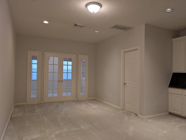 7222 Harmony Cv, Houston, TX 77036 - spare room with light carpet, a textured ceiling, baseboards, french doors, and recessed lighting