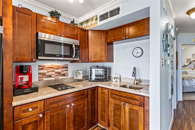 6300 Seawall Blvd Unit 9115, Galveston, TX 77551 - kitchen with stainless steel microwave, a sink, crown molding, a textured ceiling, and dark wood-type flooring