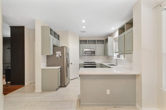 718 Presley Way, Sugar Land, TX 77479 - kitchen with appliances with stainless steel finishes, a peninsula, tasteful backsplash, a sink, and recessed lighting