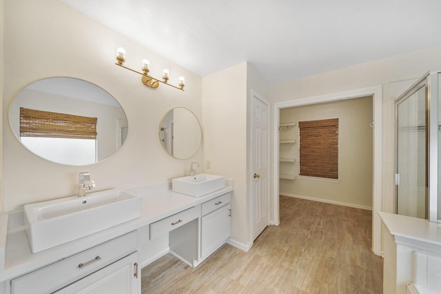 718 Presley Way, Sugar Land, TX 77479 - bathroom featuring double vanity, wood finished floors, a shower with shower door, a closet, and baseboards