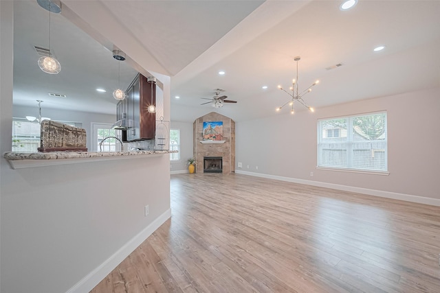 2902 Secluded Dr, Sugar Land, TX 77498 - unfurnished living room featuring a chandelier, a fireplace, light wood-type flooring, ceiling fan, and baseboards