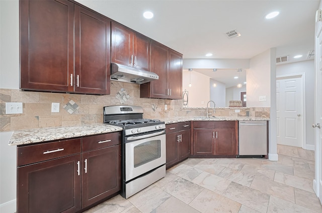 2902 Secluded Dr, Sugar Land, TX 77498 - kitchen with stainless steel appliances, under cabinet range hood, a sink, decorative backsplash, and recessed lighting
