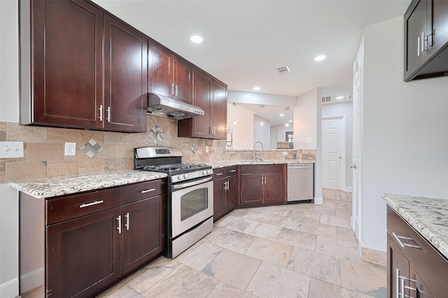 2902 Secluded Dr, Sugar Land, TX 77498 - kitchen featuring appliances with stainless steel finishes, under cabinet range hood, backsplash, light stone counters, and a sink