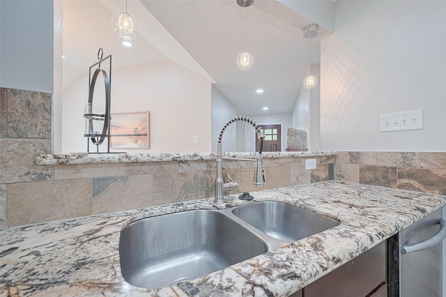 2902 Secluded Dr, Sugar Land, TX 77498 - kitchen view of a sink, light stone countertops, tile walls, and decorative light fixtures