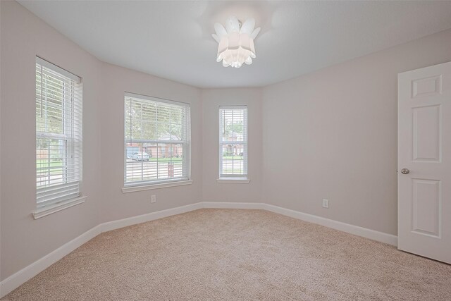 2902 Secluded Dr, Sugar Land, TX 77498 - empty room with light carpet, baseboards, and a chandelier