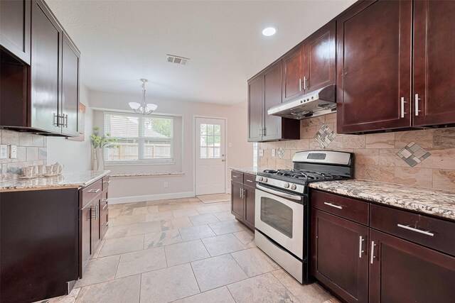 2902 Secluded Dr, Sugar Land, TX 77498 - kitchen featuring stainless steel gas range, under cabinet range hood, baseboards, light stone countertops, and decorative backsplash