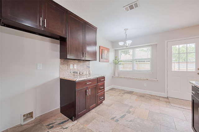2902 Secluded Dr, Sugar Land, TX 77498 - kitchen with tasteful backsplash, baseboards, a chandelier, light stone counters, and dark brown cabinetry