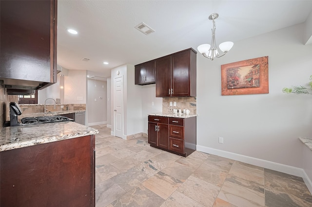 2902 Secluded Dr, Sugar Land, TX 77498 - kitchen featuring tasteful backsplash, baseboards, dark brown cabinetry, light stone countertops, and a chandelier