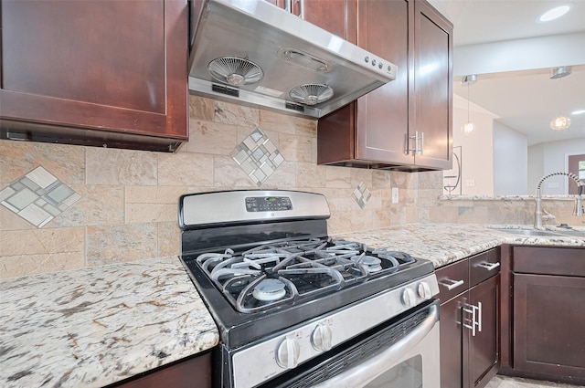2902 Secluded Dr, Sugar Land, TX 77498 - kitchen with stainless steel range with gas stovetop, range hood, a sink, light stone counters, and decorative backsplash
