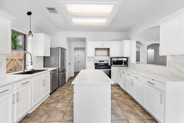 1919 W Welsford Dr, Spring, TX 77386 - kitchen with stainless steel appliances, a sink, a kitchen island, white cabinets, and lofted ceiling