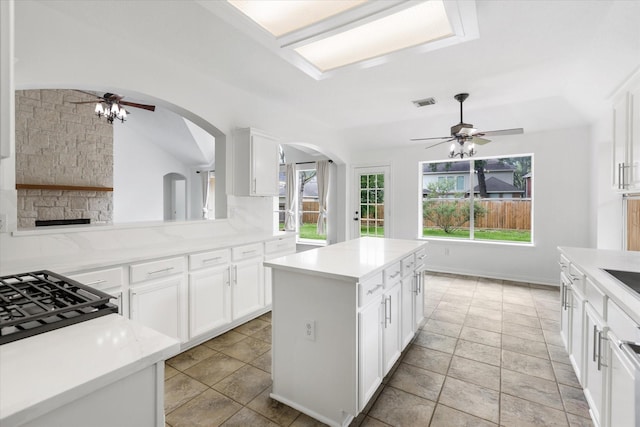 1919 W Welsford Dr, Spring, TX 77386 - kitchen featuring a ceiling fan, arched walkways, a center island, white cabinets, and vaulted ceiling