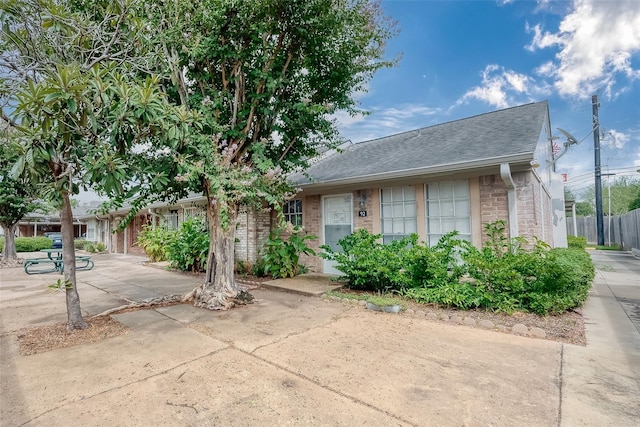 1016 Tri Oaks Ln Unit 92, Houston, TX 77043 - view of front of home with brick siding, roof with shingles, and a patio