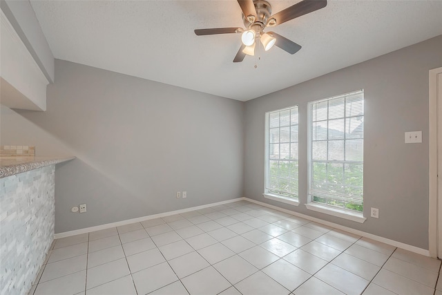1016 Tri Oaks Ln Unit 92, Houston, TX 77043 - empty room with light tile patterned floors, a ceiling fan, baseboards, and a textured ceiling
