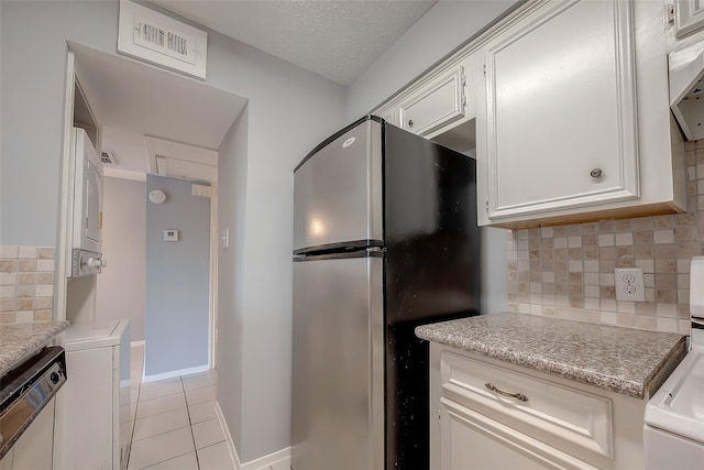 1016 Tri Oaks Ln Unit 92, Houston, TX 77043 - kitchen with stainless steel appliances, decorative backsplash, light tile patterned floors, white cabinets, and baseboards