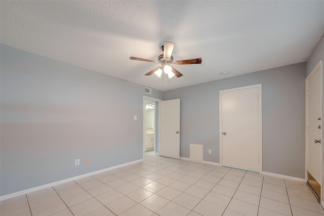 1016 Tri Oaks Ln Unit 92, Houston, TX 77043 - unfurnished bedroom featuring baseboards, ceiling fan, light tile patterned floors, and a textured ceiling