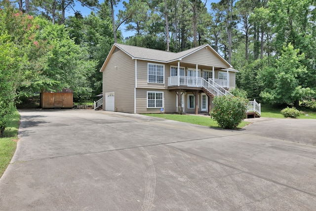 360 Holiday Ln, Coldspring, TX 77331 - view of front of property with stairway, concrete driveway, a porch, an attached garage, and view of wooded area