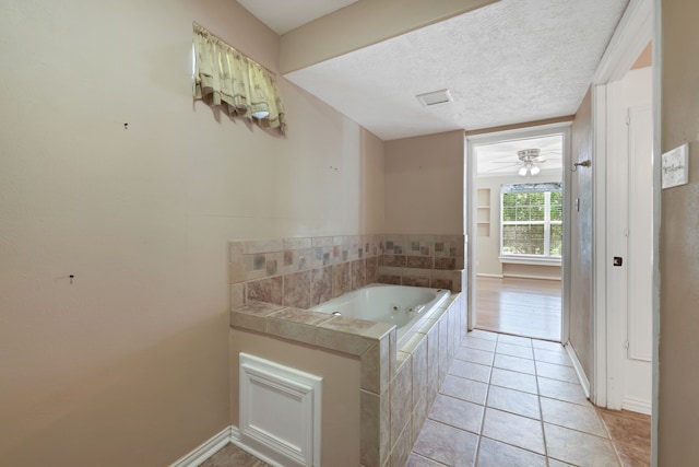 360 Holiday Ln, Coldspring, TX 77331 - bathroom with a whirlpool tub, baseboards, tile patterned floors, a textured ceiling, and ceiling fan