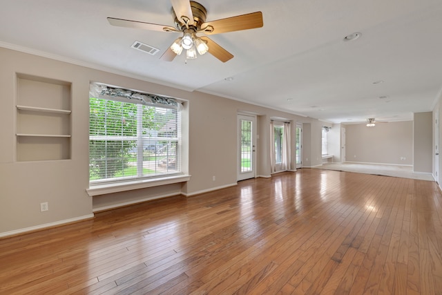 360 Holiday Ln, Coldspring, TX 77331 - unfurnished living room with ornamental molding, ceiling fan, hardwood / wood-style floors, baseboards, and built in shelves