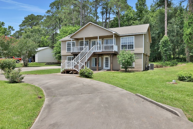 360 Holiday Ln, Coldspring, TX 77331 - view of front of home with central AC, covered porch, concrete driveway, stairway, and a front yard