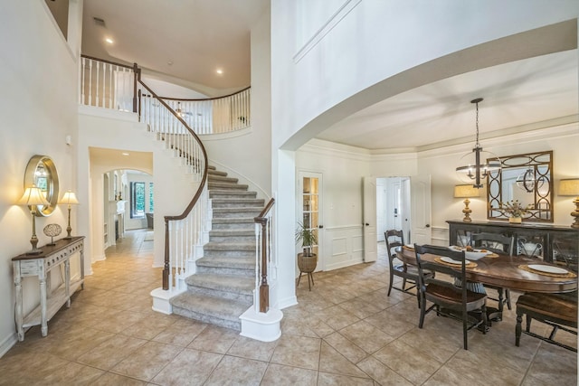 17407 W Blooming Rose Ct, Cypress, TX 77429 - dining room featuring arched walkways, stairway, a towering ceiling, light tile patterned floors, and a chandelier