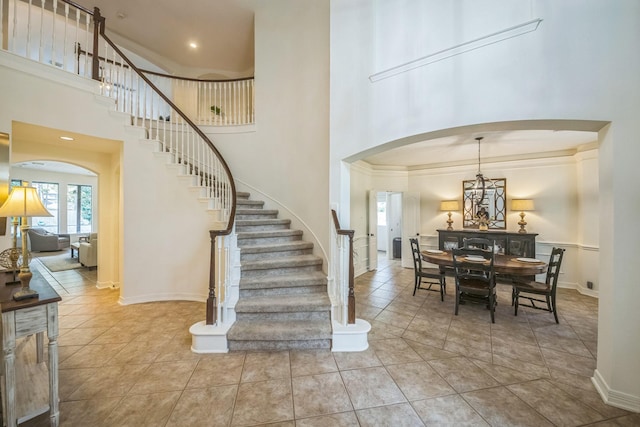 17407 W Blooming Rose Ct, Cypress, TX 77429 - tiled entrance foyer with arched walkways, stairway, a high ceiling, and baseboards