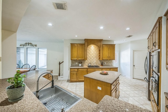 17407 W Blooming Rose Ct, Cypress, TX 77429 - kitchen featuring a sink, freestanding refrigerator, tasteful backsplash, a center island, and light tile patterned floors