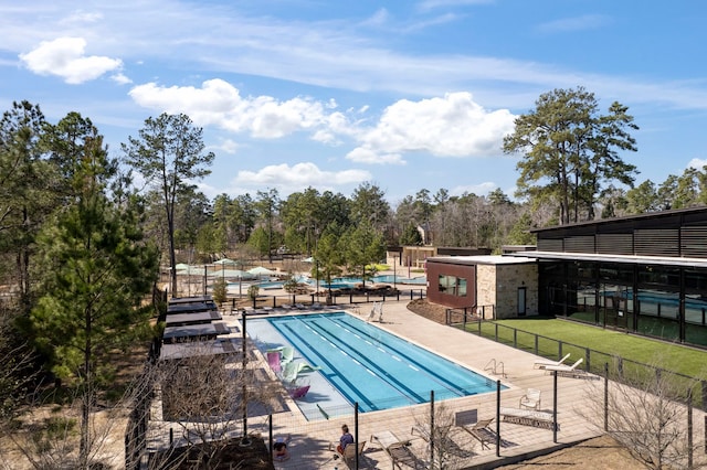 121 N Cadence Hills Loop, Conroe, TX 77318 - community pool with a patio area and view of scattered trees