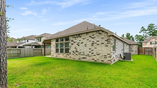 121 N Cadence Hills Loop, Conroe, TX 77318 - back of property with a fenced backyard, brick siding, and roof with shingles
