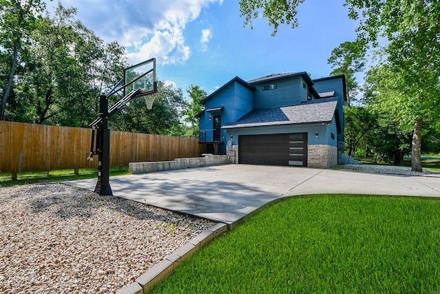 11007 Olde Mint House Ln, Tomball, TX 77375 - view of side of property featuring stone siding, concrete driveway, an attached garage, and a shingled roof