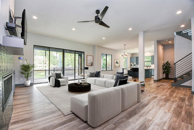 11007 Olde Mint House Ln, Tomball, TX 77375 - living area featuring recessed lighting, stairs, light wood-style flooring, ceiling fan, and a fireplace