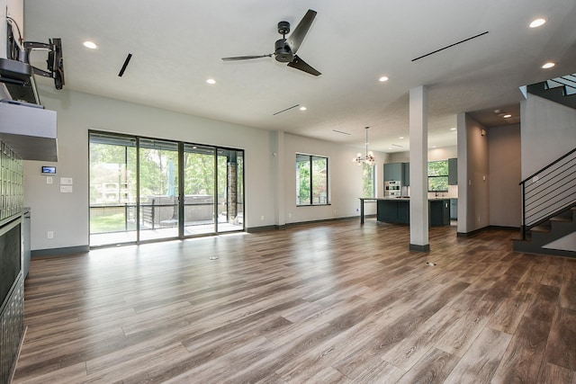 11007 Olde Mint House Ln, Tomball, TX 77375 - unfurnished living room featuring healthy amount of natural light, stairway, baseboards, recessed lighting, and dark wood-type flooring