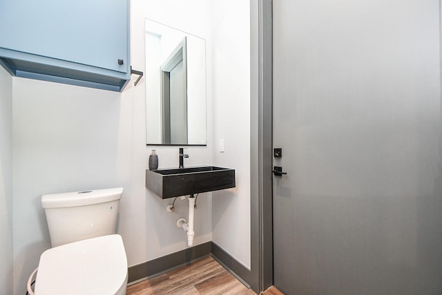 11007 Olde Mint House Ln, Tomball, TX 77375 - bathroom featuring toilet, wood finished floors, a sink, and baseboards