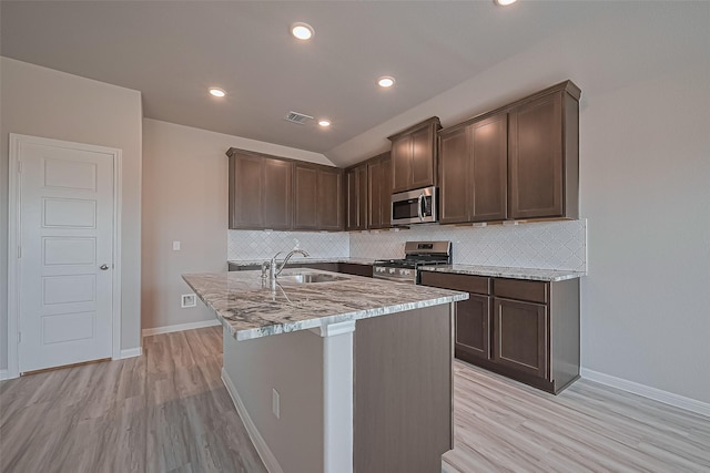 27227 Blue Pool Dr, Katy, TX 77493 - kitchen featuring appliances with stainless steel finishes, a sink, light wood-style flooring, tasteful backsplash, and recessed lighting
