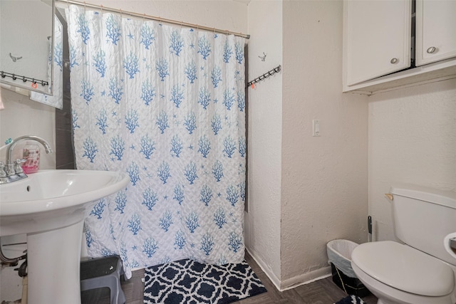 7512 Amarillo St, Houston, TX 77020 - bathroom featuring toilet, a shower with curtain, baseboards, a textured wall, and a sink