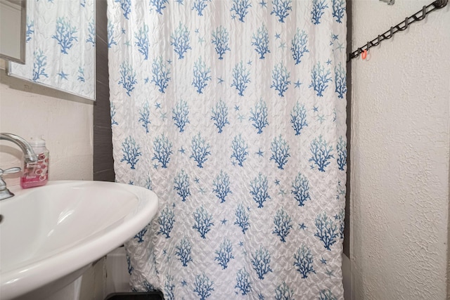 7512 Amarillo St, Houston, TX 77020 - bathroom featuring a sink, a textured wall, and a shower with curtain