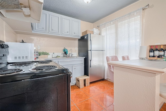 7512 Amarillo St, Houston, TX 77020 - kitchen featuring black electric range, freestanding refrigerator, light countertops, range hood, and white cabinetry