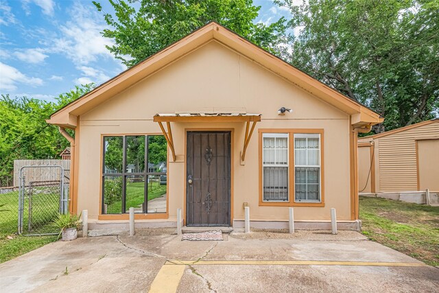7512 Amarillo St, Houston, TX 77020 - view of front of home featuring stucco siding, a gate, and a patio